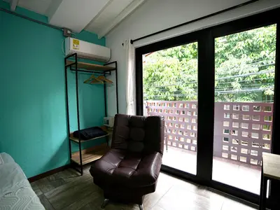 a leather chair in a room with a large window at CoLinkHouse Hotel in Medellín