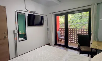 a room with a bed and a door with a window at CoLinkHouse Hotel in Medellín