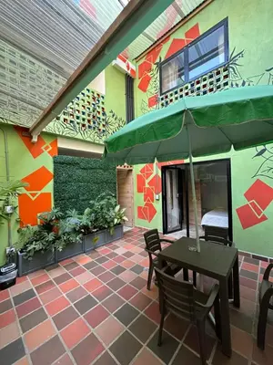 a patio with an umbrella and a table and chairs at CoLinkHouse Hotel in Medellín