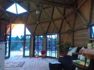 a living room with a large wooden ceiling at Unique Glamping / Domo Betsaida in Guatapé