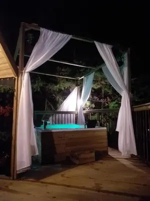 an outdoor stage with a white canopy and curtains at Unique Glamping / Domo Betsaida in Guatapé