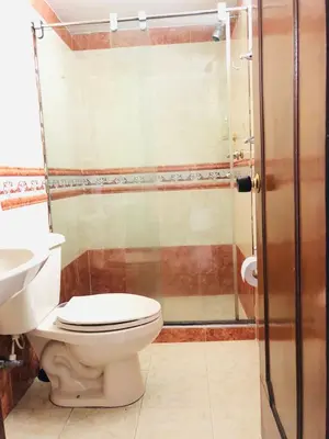 a bathroom with a toilet and a glass shower at Alojamiento Laureles la 33 in Medellín