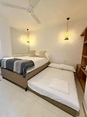 two beds in a room with lights on the wall at Apartamento de Descanso - Doradal in Doradal