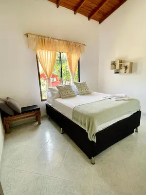 a bedroom with a large bed with a window at Apartamento de Descanso - Doradal in Doradal