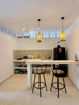 a kitchen with a counter and two bar stools at Apartamento de Descanso - Doradal in Doradal