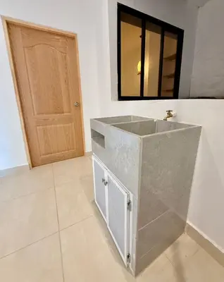 a bathroom with a sink and a wooden door at Apartamento de Descanso - Doradal in Doradal