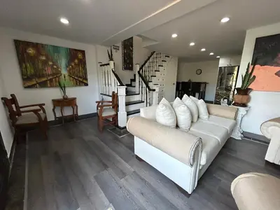a living room with a white couch and stairs at El Balcón De Las Montañas in Medellín