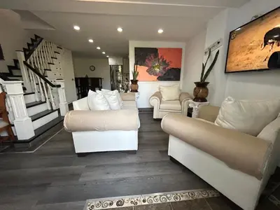 a living room with white couches and a staircase at El Balcón De Las Montañas in Medellín