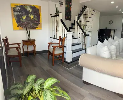 a living room with a couch and chairs and stairs at El Balcón De Las Montañas in Medellín