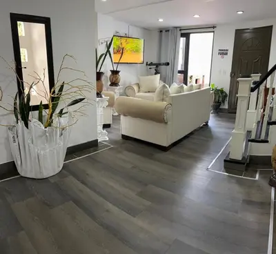 a living room with a white couch and wooden floors at El Balcón De Las Montañas in Medellín