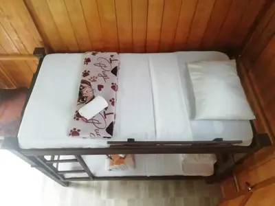 a bed in a room with white sheets and pillows at Cabañas orquídea in Norcasia