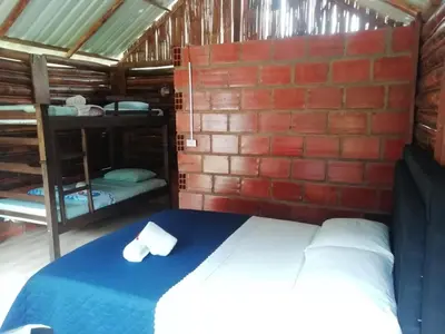 a bedroom with two bunk beds and a brick wall at Cabañas orquídea in Norcasia