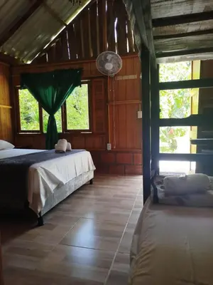 a bedroom with two beds in a room with windows at Cabañas orquídea in Norcasia