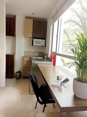 a kitchen with a wooden table and a large window at Laureles Guest House LGH Hotel in Medellín