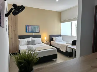 a hotel room with two beds and a couch at Laureles Guest House LGH Hotel in Medellín
