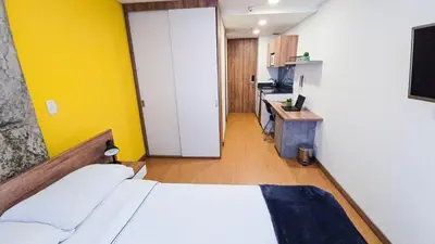 a bedroom with a bed and a desk with a television at Ulivin Coliving in Manizales