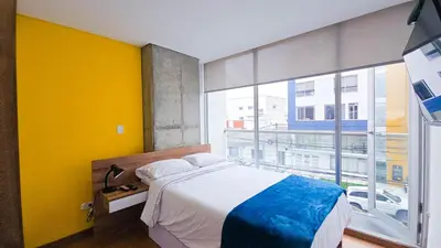 a bedroom with a bed and a large window at Ulivin Coliving in Manizales