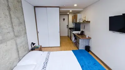 a bedroom with a bed and a tv in a room at Ulivin Coliving in Manizales