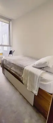 a large bed in a room with a window at Ulivin Coliving in Manizales