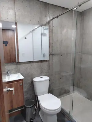 a bathroom with a toilet and a glass shower at Ulivin Coliving in Manizales