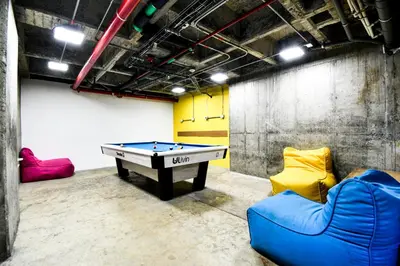 a room with a pool table and two chairs at Ulivin Coliving in Manizales