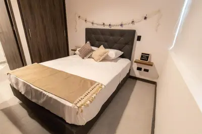 a bedroom with a large bed with white sheets and pillows at Casa García Rent Home in Guatapé