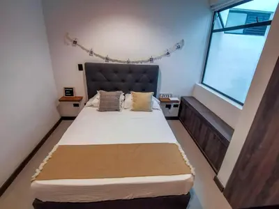a bedroom with a large bed with a large window at Casa García Rent Home in Guatapé