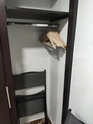 a closet with a black shelf and a black chair at Hermoso apto con excelente vista in Bello