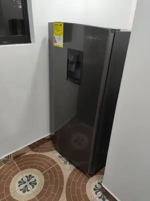 a small black refrigerator in a corner of a room at Hermoso apto con excelente vista in Bello