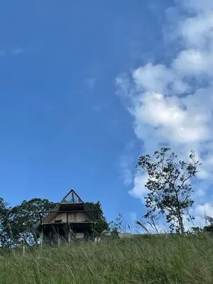 an old house sitting on top of a grassy hill at Casa Mostaza-Ecolodge in Samaná