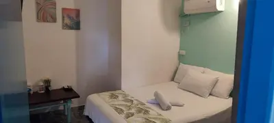 a small bedroom with a bed and a desk at Cabaña Nro 80 El Portón de La Aldea in Doradal