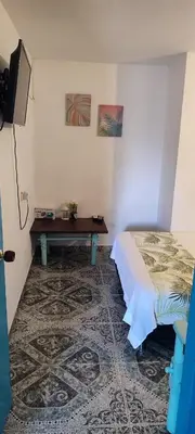 a bedroom with a bed and a table in it at Cabaña Nro 80 El Portón de La Aldea in Doradal
