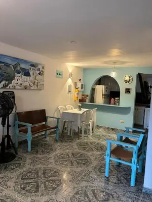 a living room with a table and chairs and a kitchen at Cabaña Nro 80 El Portón de La Aldea in Doradal