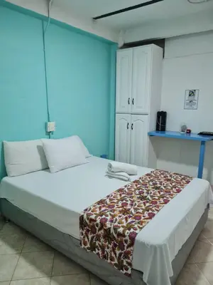 a bedroom with a large white bed with blue walls at Cabaña Nro 80 El Portón de La Aldea in Doradal