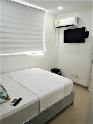 a bedroom with a bed and a window with a heater at Acogedor, Gran Vista a las Montañas y a la Ciudad! in Santa Fe de Antioquia