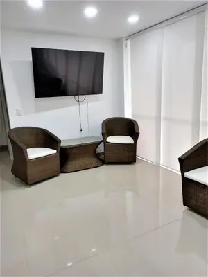 a living room with wicker chairs and a flat screen tv at Acogedor, Gran Vista a las Montañas y a la Ciudad! in Santa Fe de Antioquia