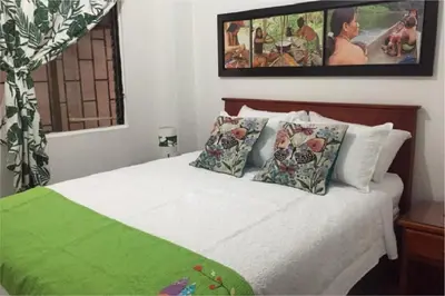 a bedroom with a white bed with pillows at Etnias Hotel tematico in Quibdó
