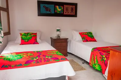a bedroom with two beds with red and green sheets at Etnias Hotel tematico in Quibdó