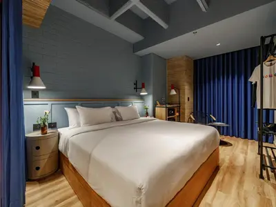 a bedroom with a large white bed and blue walls at The Somos Bold Hotel in Medellín