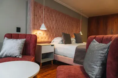 a hotel room with a bed and two chairs at Hotel Entre Brumas in Aguadas