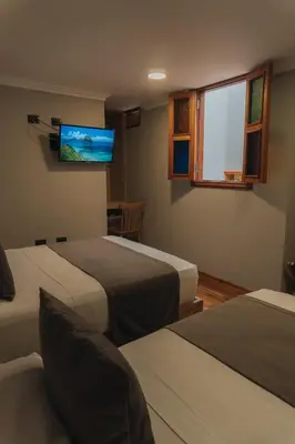 a hotel room with two beds and a flat screen tv at Hotel Entre Brumas in Aguadas
