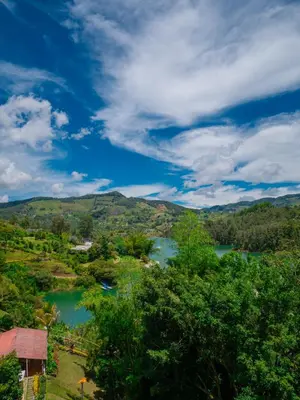 a view of a river with trees and mountains at Descanso Bajo La Piedra Del Peñol in Guatapé