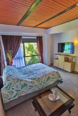 a bedroom with a bed and a large window at Descanso Bajo La Piedra Del Peñol in Guatapé