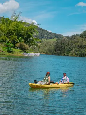 two people in a yellow kayak on a lake at Descanso Bajo La Piedra Del Peñol in Guatapé