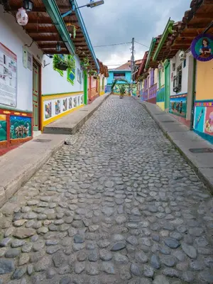 a cobblestone street in a town with colorful buildings at Descanso Bajo La Piedra Del Peñol in Guatapé