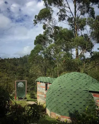 a small building with a green roof in a field at PrivaDome in Rionegro