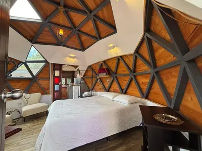 a bedroom with a large wooden ceiling at PrivaDome in Rionegro