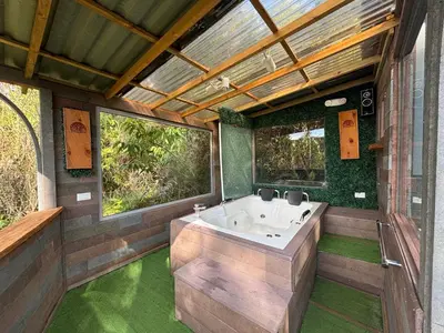 a large bathroom with a tub and green floor at PrivaDome in Rionegro