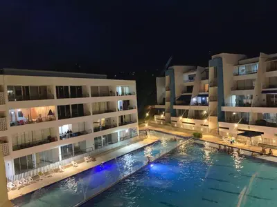 a swimming pool in front of two buildings at night at Edén de Alejo - Apartamento - Lujo y Confort en San Jerónimo in San Jerónimo