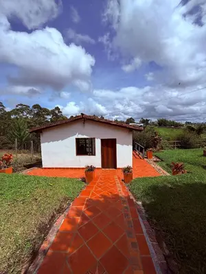 a small white house with a red brick walk at San José de las bromelias in Marinilla